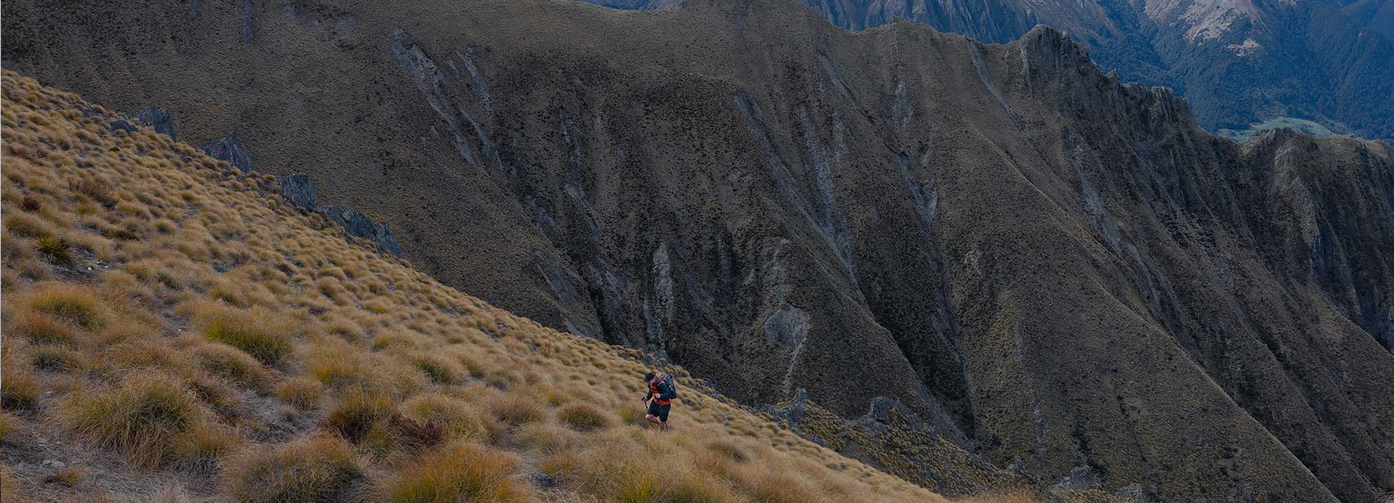 A male hiker ascending a steep incline.
