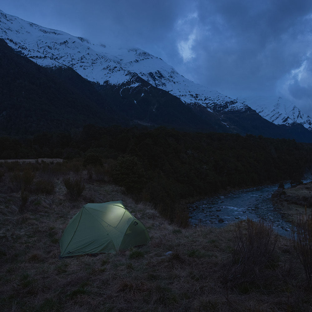 A tent at dust infront of big mountains