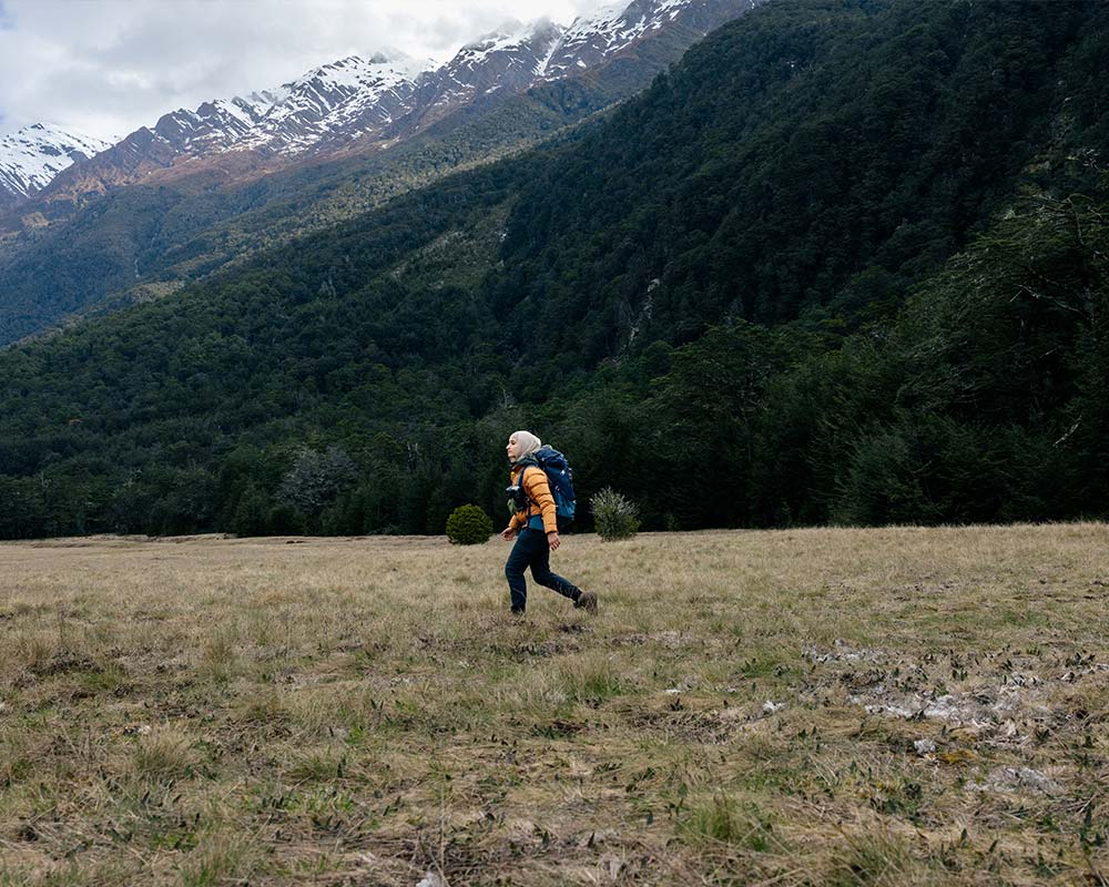 A female hiker outdoors a valley between mountains